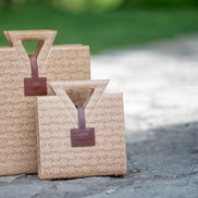The Jane Tote and Jane Tote Mini in raffia-embossed leather, side by side outdoors