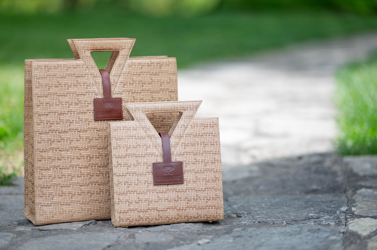 The Jane Tote and Jane Tote Mini in raffia-embossed leather, side by side outdoors
