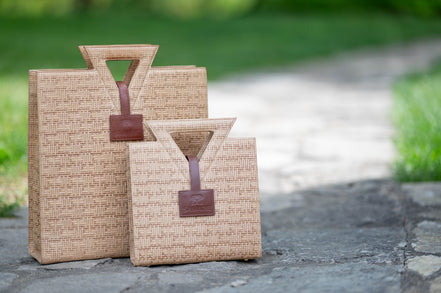The Jane Tote and Jane Tote Mini in raffia-embossed leather, side by side outdoors